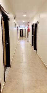 einen langen Flur mit Türen und Fliesenboden in der Unterkunft Asia Hotel in Riad