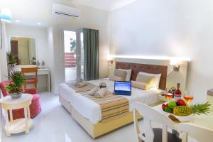 a bedroom with a bed with a laptop on it at Camelot Royal Beds by Estia in Malia