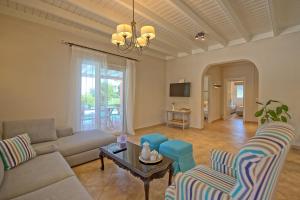 a living room with a couch and chairs and a table at Beach Villa Joanna by PosarelliVillas in Acharavi