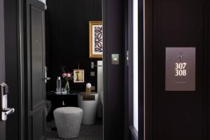 - une salle de bains noire avec des toilettes et une table dans l'établissement Le Damantin Hôtel & Spa, à Paris