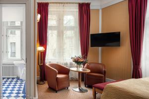 a living room filled with furniture and a tv at Hotel Paris Prague in Prague