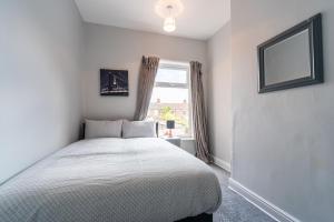 a white bedroom with a bed and a window at 3 Bedroom Hull Sleeps 6 Glam Contractor & Leisure & Families Close to Clough Rd in Hull