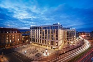 a rendering of a building in a city at night at HYPERION Hotel Leipzig in Leipzig