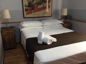 Vacanze Romane 2 في روما: منشفتان على سرير في غرفة الفندق