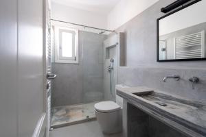 uma casa de banho com um chuveiro, um WC e um lavatório. em Armenistis Apartment em Naousa