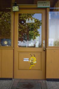 een gele deur met een smiley erop geschilderd bij Bee House Maya in Rob