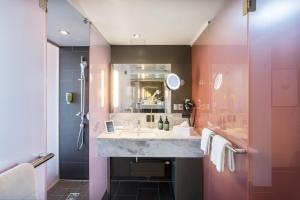 a bathroom with a sink and a shower at voco Villach by IHG in Villach