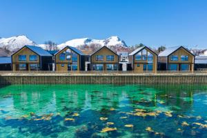 a pool of water in front of a row of houses at Risøyhamn Sjøhus AS in Risøyhamn