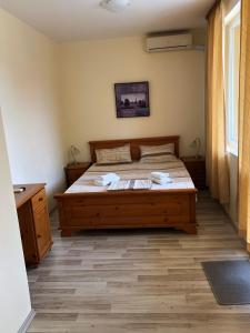 een slaapkamer met een bed met een houten bedframe bij Семеен хотел Авалон in Chernomorets