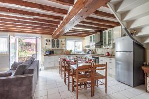 a kitchen with a table with chairs and a refrigerator at Gîte Leomie - Maison en pierre au pied des vignes - Monthurel in Monthurel