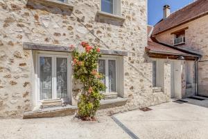 a building with areath of flowers on the side of it at Gîte Leomie - Maison en pierre au pied des vignes - Monthurel in Monthurel