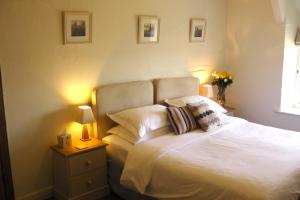 a bedroom with a white bed with two pillows at Lellizzick Farmhouse in Padstow