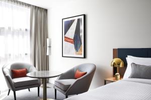 una camera d'albergo con letto, tavolo e sedie di Crowne Plaza Sydney Darling Harbour, an IHG Hotel a Sydney