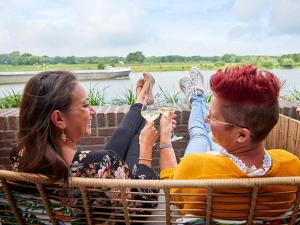 a man and woman sitting in a chair drinking wine at De Maasparel Nextdoor Suites in Arcen