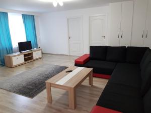 Sala de estar con sofá negro y mesa de centro en Apartament 8 Central en Târgu Mureș