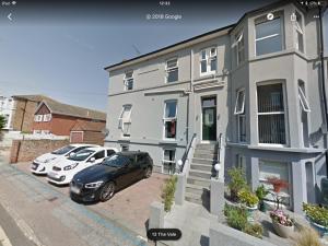 una casa con dos coches estacionados frente a ella en Merriland, en Broadstairs