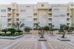 een gebouw met bomen ervoor bij Marina Apartments by Olala Homes in Herzliyya B +24 foto's