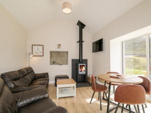 a living room with a couch and a table and a fireplace at Deer House in Oldshore