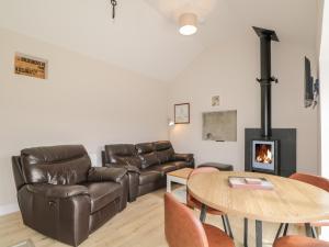 a living room with a couch and a table and a fireplace at Deer House in Oldshore