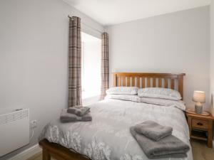 a bedroom with a bed with two towels on it at Deer House in Oldshore