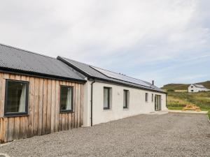 a group of buildings with a gravel driveway at Deer House in Oldshore