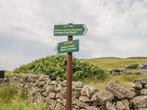 a street sign in front of a stone wall at Deer House in Oldshore