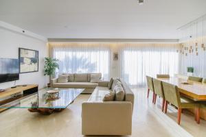 Marina Apartments by Olala Homes في حرزيليا بي: غرفة معيشة مع أريكة وطاولة