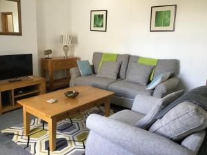 sala de estar con sofá, 2 sillas y mesa en Merriland, en Broadstairs