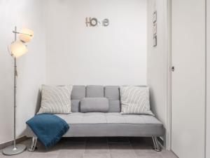 Apartment Beni-1 by Interhome في ماتولي: أريكة رمادية في غرفة بيضاء مع مصباح