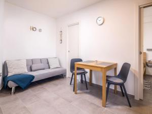 uma sala de estar com um sofá, uma mesa e cadeiras em Apartment Beni-1 by Interhome em Matulji