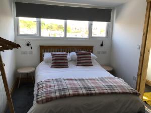 1 dormitorio con 1 cama con 2 almohadas y ventana en Merriland, en Broadstairs