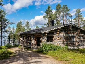 an old log cabin with a black roof at Holiday Home Villa mitja by Interhome in Karjalaisenniemi