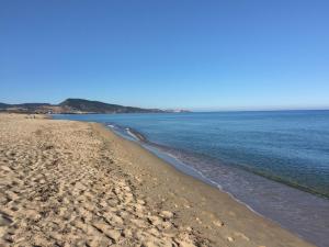 ein Sandstrand mit dem Meer im Hintergrund in der Unterkunft Holiday Home San Pietro Green by Interhome in Valledoria