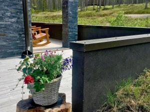 a potted plant sitting on a wooden stump on a porch at Holiday Home Levi hillside by Interhome in Levi