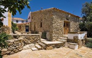an old stone house with a stone wall and stairs at Aldeia da Mata Pequena in Mafra