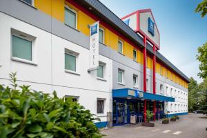 a large white building with a colorful facade at ibis budget Mannheim Friedrichsfeld in Mannheim