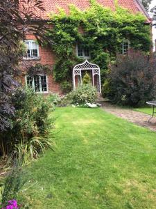 une maison en briques avec une porte blanche dans une cour dans l'établissement Bottesford Cottage - Leicestershire, à Bottesford