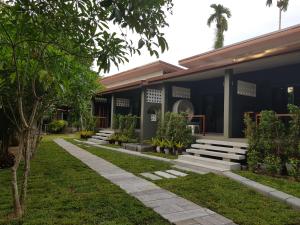 a house with a walkway in front of it at Khaolak Yama Resort - SHA Plus in Khao Lak
