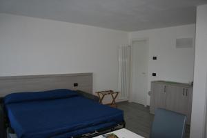 a bedroom with a bed and a desk and a chair at appartamenti i fiori del lago in Laveno-Mombello