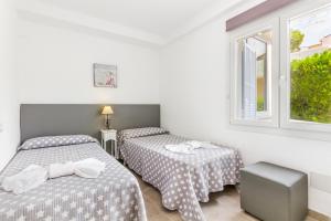 a room with two beds and a window at Playamar - Private Pool and 150m to Beach in Alcudia +19 photos