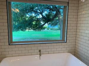 La salle de bains est pourvue d'une baignoire et d'une fenêtre. dans l'établissement Salado Cottage Retreat near Downtown, à Salado