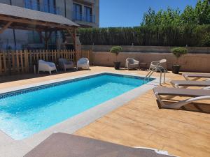 a swimming pool with two chairs and a table at Casa Galiñanes in Portonovo