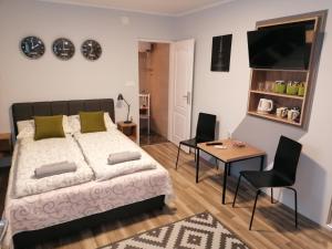 a bedroom with a bed and a table and chairs at Sombor 19 Central Apartment in Sombor