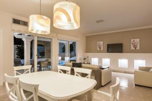 comedor y sala de estar con mesa blanca y sillas en Bahiazul Villas Corralejo by Vreagestion, en Corralejo
