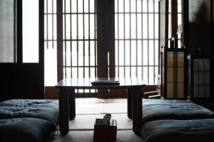 a room with a table in front of a large window at Minsyuku Koshiyama in Shirakawa