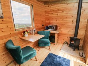 a room with a table and chairs and a stove at Shepherd's Hut in Scarborough