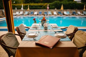 a table set for a meal in front of a pool at Canada Hotel & Bungalows in Cıralı