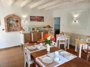 a dining room with a table with flowers on it at Le Zampolle B & B in Colà di Lazise