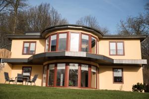 ein großes gelbes Haus mit roten Fenstern und einem Tisch in der Unterkunft Hinter Dem Schloss in Schleswig