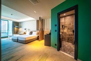 a hotel room with a bed and a bathroom at HVD Reina del Mar - Premium Spa Service & Free Parking in Obzor